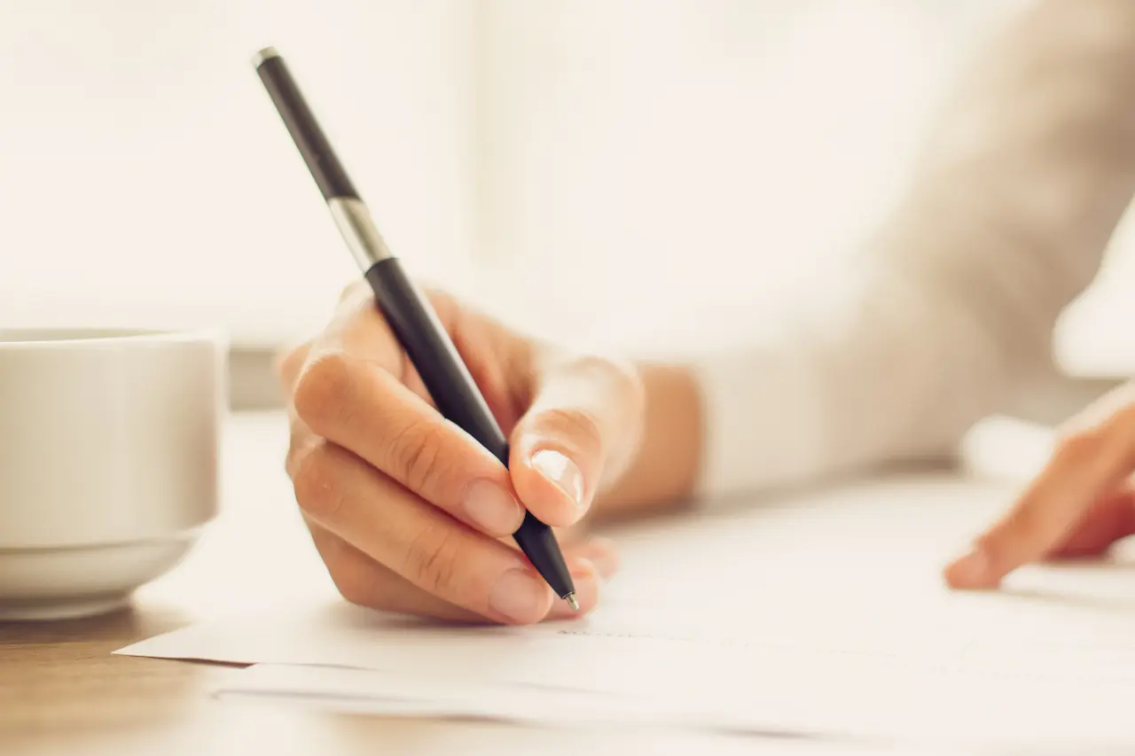 Hand van vrouw schrijvend op papier